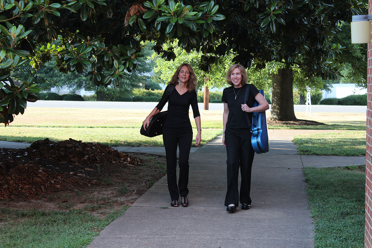 Margie Heath and Jill Foster from Jolie Deux RVA Violin Duo walking with cases